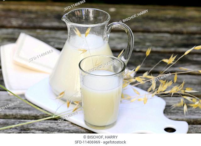 Oat milk in a glass and a jug