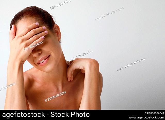 Mature woman shoulder off posing over white wall. High quality photo. Isolated