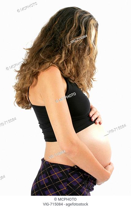 long-haired pregnant woman looking at her belly, pregnant woman touching her naked belly with both hands.  - 24/08/2005