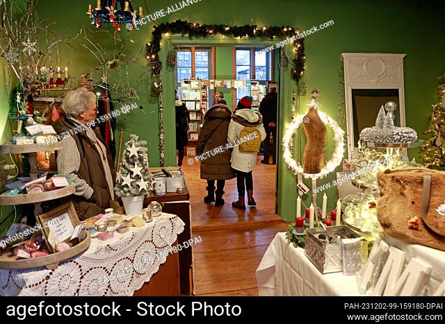 02 December 2023, Saxony-Anhalt, Quedlinburg: Gabriele Velster stands at her stall in the Advent House. The creator of Advent in den Höfen attracted many...