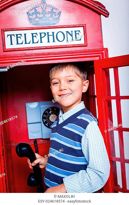 Cute little boy in the red telephone box