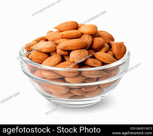 Glass bowl of peeled apricot kernels isolated on white