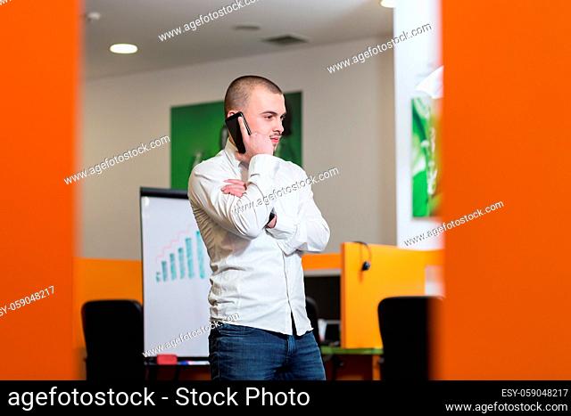 Portrait of a serious confident man boss having mobile phone conversation while resting after meeting with his partners, businessman talking on cell telephone...