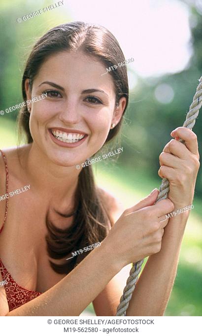 smiling girl on a rope swing