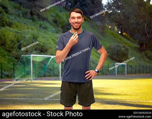 smiling male soccer coach or referee with whistle