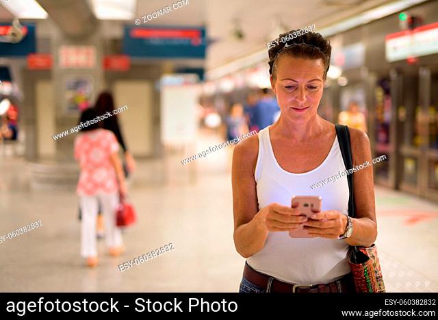 Portrait of beautiful mature tourist woman enjoying life while travelling in Singapore city