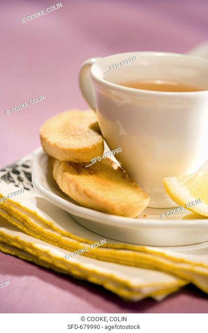 Cup of Tea on a Saucer with Biscotti and Lemon Wedge