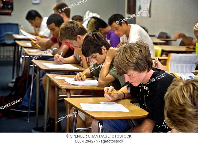 A multiracial Southern California high school class takes a multiple choice test, marking the answers on a Scantron card with a pencil to allow electronic...
