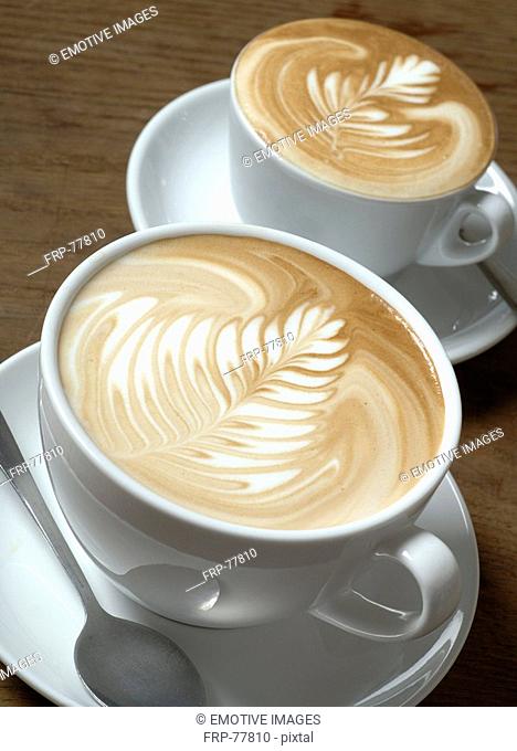 Two cappuccini with milk froth ornaments