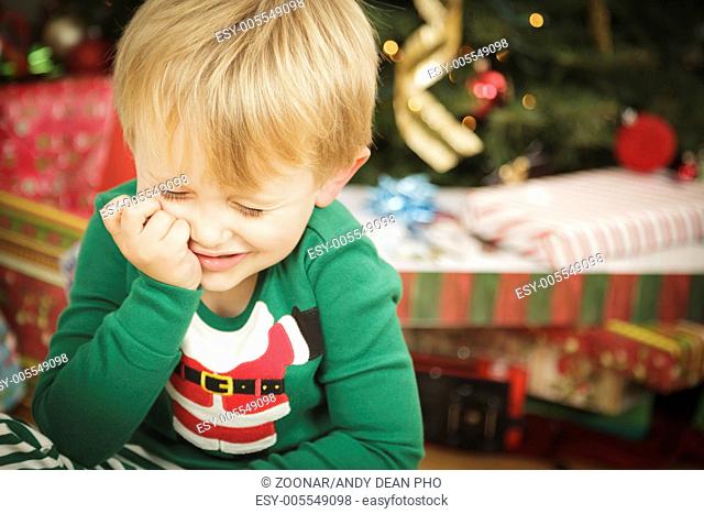 Young Grumpy Boy Sitting Near Christmas Tree