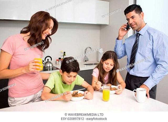 Kids with parents having breakfast in kitchen