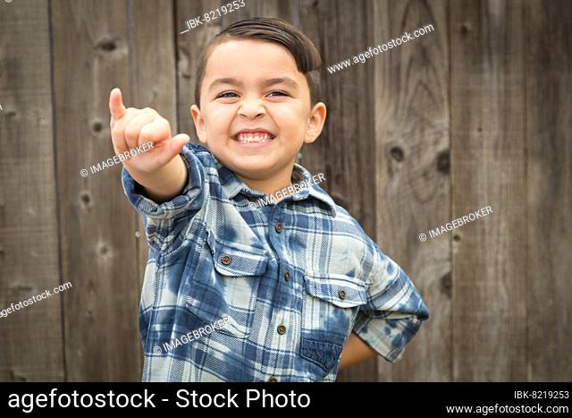 Happy young mixed-race boy making hawaiin shaka hand gesture