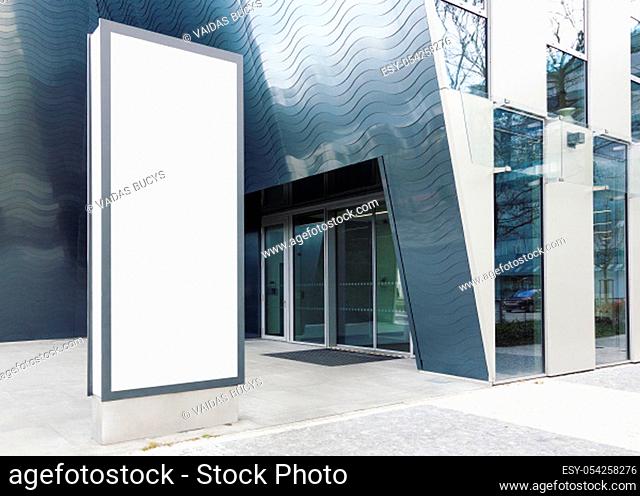 Blank standing outdoor billboard with white copy space to add multiple company names and logos with modern office building in background