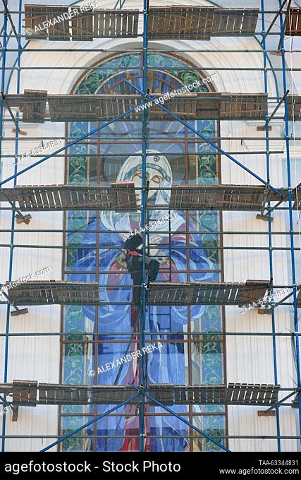 RUSSIA, LUGANSK - OCTOBER 14, 2023: A man climbs scaffolds as reconstruction works continue on the Church of Our Lady of Tenderness during the Christian feast...