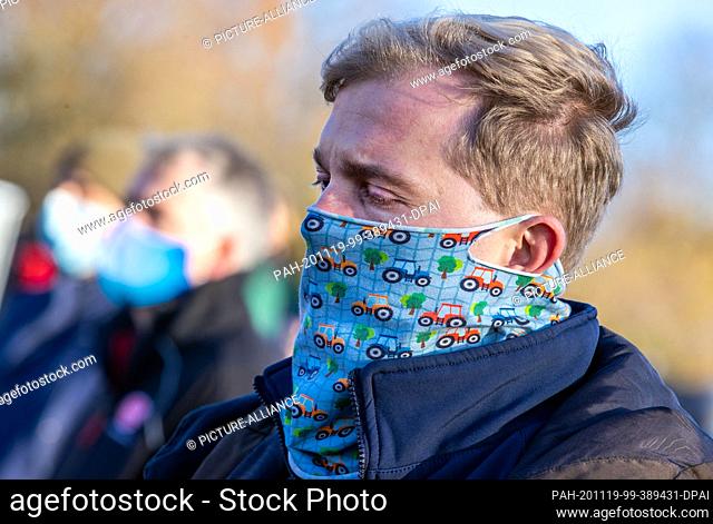 19 November 2020, Mecklenburg-Western Pomerania, Wismar: Dairy farmer Nils Postma stands with mouth and nose protection at a protest action of farmers in front...