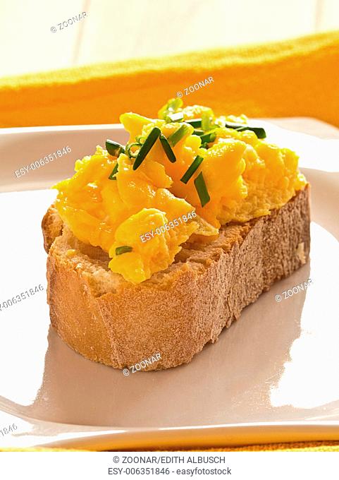 Scrambled eggs with chives garnished on a plate Ba