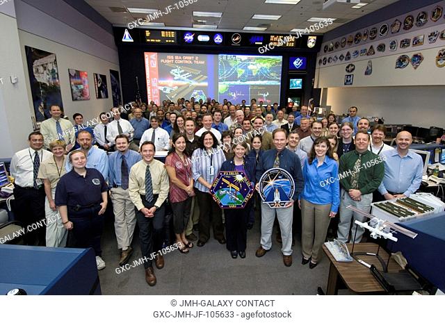 The members of the STS-11512A ISS Orbit 2 flight control team pose for a group portrait in the Station (Blue) Flight Control Room of Houston's Mission Control...
