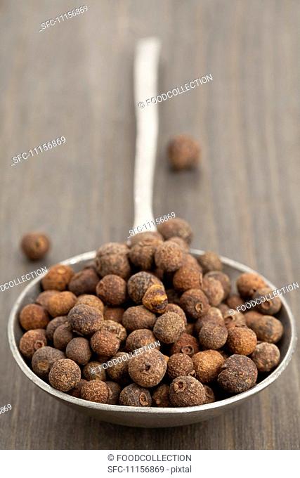 A spoon full of allspice berries