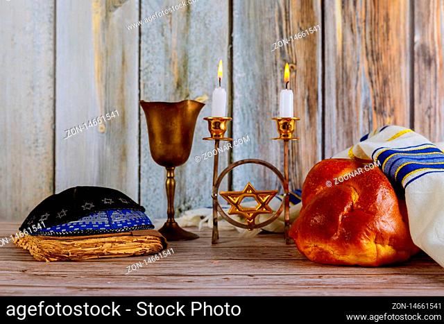Shabbat Jewish holiday with challah bread on a candles and cup of wine