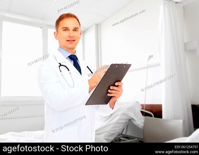 smiling male doctor with clipboard and stethoscope
