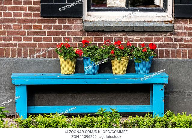 Giethoorn, The Netherlands - May 19., 2016: Blue bench with flowers in basket in the small, picturesque town of Giethoorn, Overijssel, Netherlands