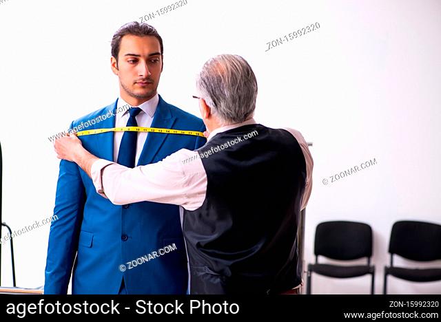 Young businessman visiting old tailor