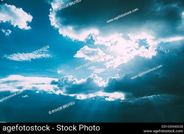 Sunrays Sunray Shine Through Dark Clouds In Cloudy Blue Sky. Natural Background. Natural Sky Backdrop Weather Conditions