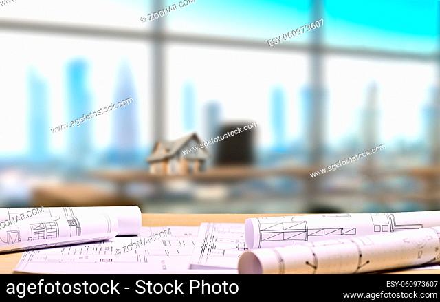 Architekturbüro mit Bauplänen und einem Architekturmodell auf einem Schreibtisch im Hintergrund