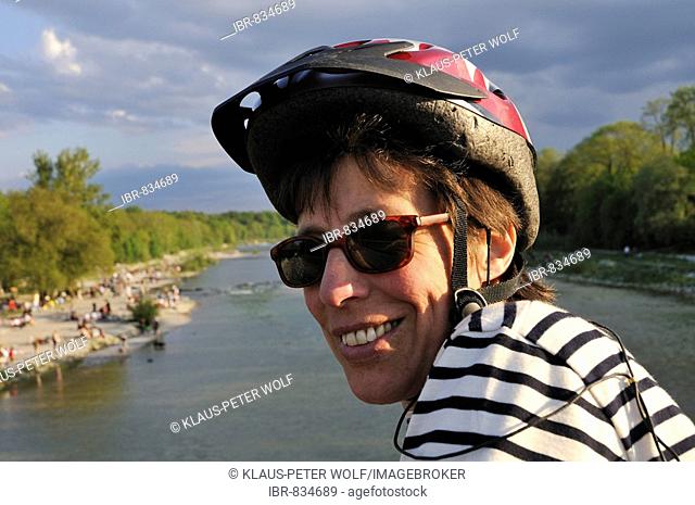Woman wearing sunglasses and bicycle helmet at the Flaucher, an offshoot of the Isar River, Munich, Upper Bavaria, Germany, Europe
