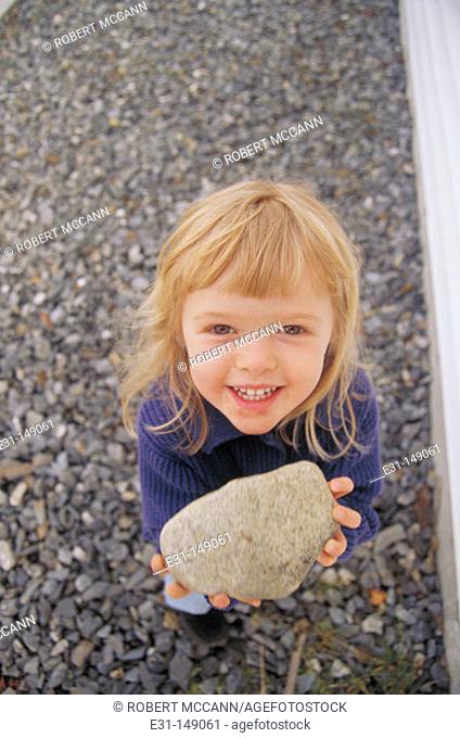 Little girl holding a rock
