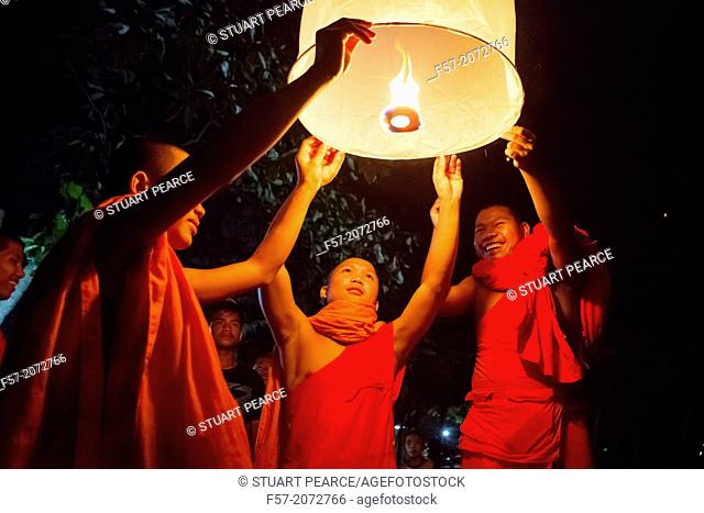 Buddhist monks lighting Chinese sky lanterns in Paske, Laos