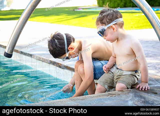 Young Mixed Race Chinese and Caucasian Brothers Wearing Swimming Goggles Playing At The Pool