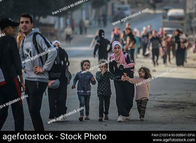 14 May 2021, Palestinian Territories, Gaza City: Palestinians flee from their houses in the Shejaiya neighbourhood during an Israeli airstrike on Gaza City amid...