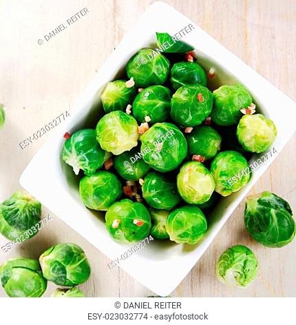 Close up Fresh Green Brussels Sprouts on White Bowl Placed on Top of Wooden Table