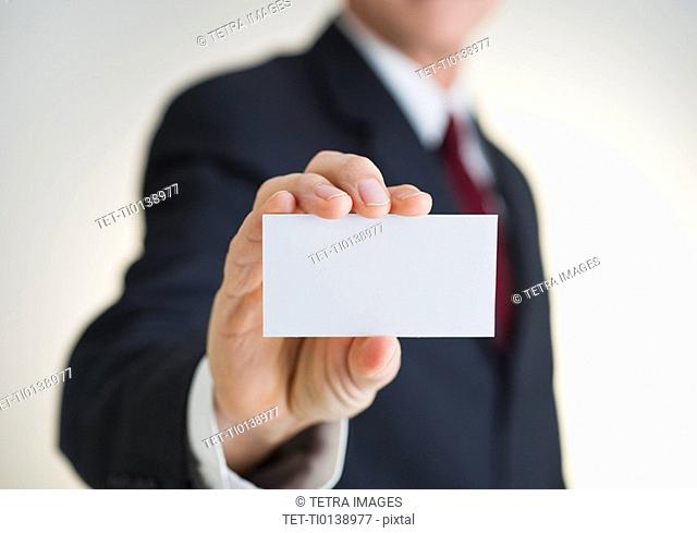 Businessman holding white card