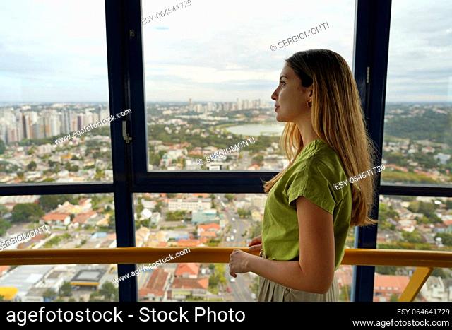 Young woman enjoying cityscape on the panoramic tower of Curitiba, Parana, Brazil