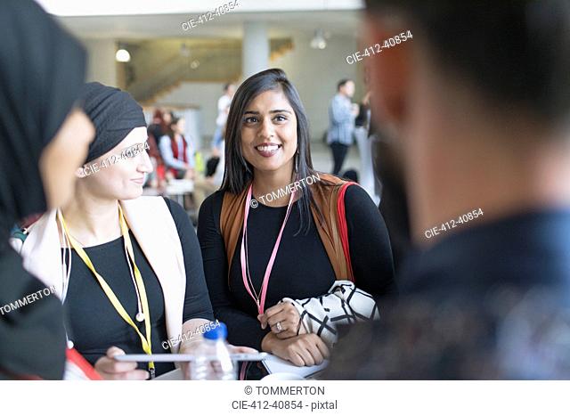 Smiling businesswomen talking at conference