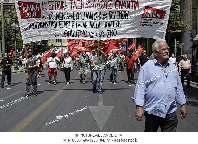 01 May 2018, Greece, Athens: Particpants of a 01 May demonstration carrying flags and banners as they march to the Greek parliament