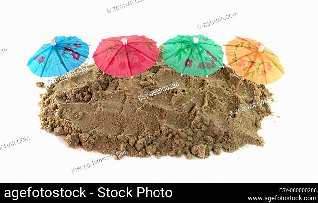 green blue red and green cocktail Umbrellas in Sand Mound
