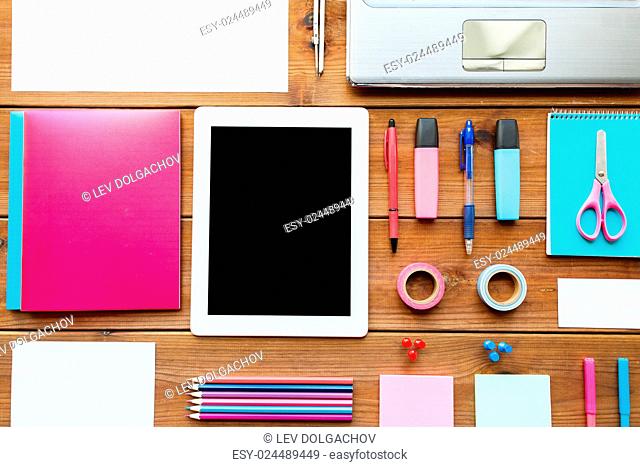 education, school supplies, art, creativity and object concept - close up of stationery and tablet pc computer on wooden table