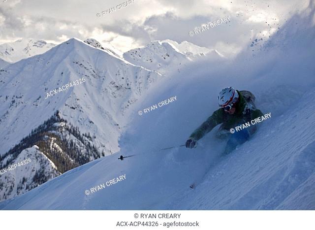 A young male skier slashes a powder turn just out of bounds at Kicking Horse Resort, Golden, Britsh Columbia, Canada