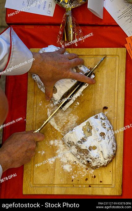 27 November 2023, Saxony-Anhalt, Magdeburg: Siegfried Brenneis from the German Bread Institute cuts a stollen during the public stollen test