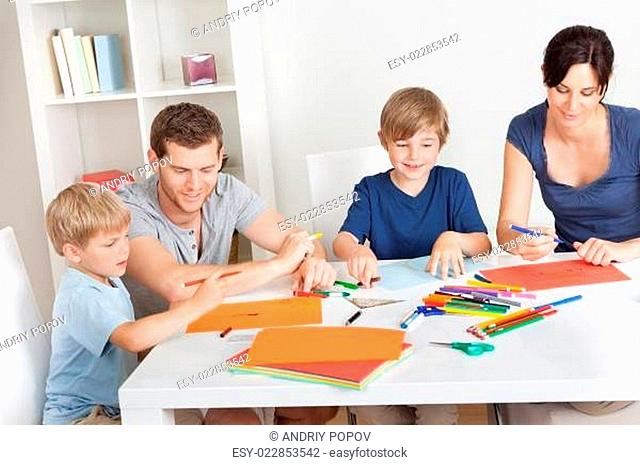 Young family drawing with colorful pencils