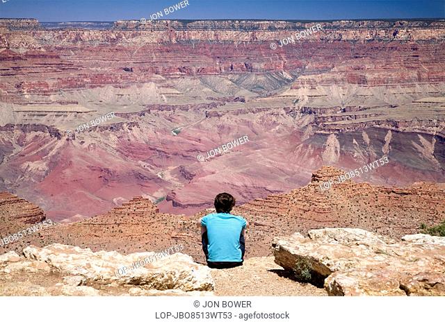 USA, Arizona, Grand Canyon. A young man looks out across the Grand Canyon