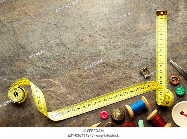 sewing tools and measuring tape on table background