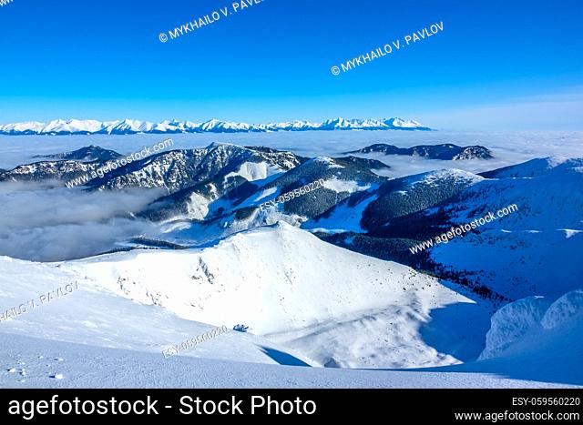 Winter Slovakia. Ski resort Jasna. Panoramic view from the top of the snow-capped mountains and fog in the valleys