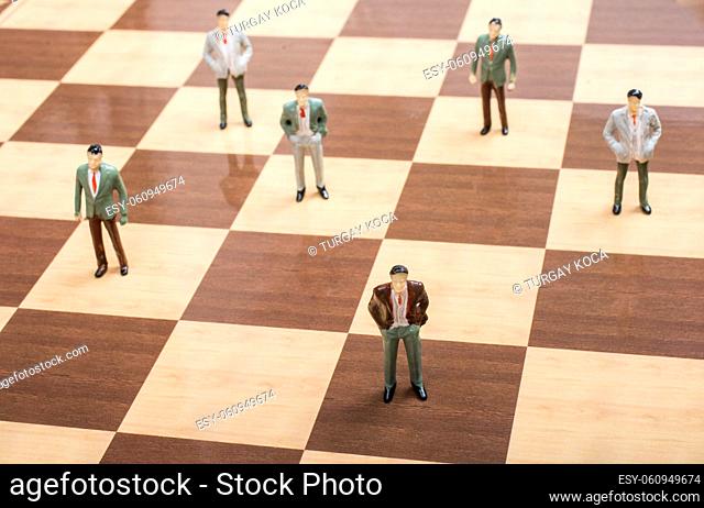 Miniature people figurine standing on chessboard as strategy Concept