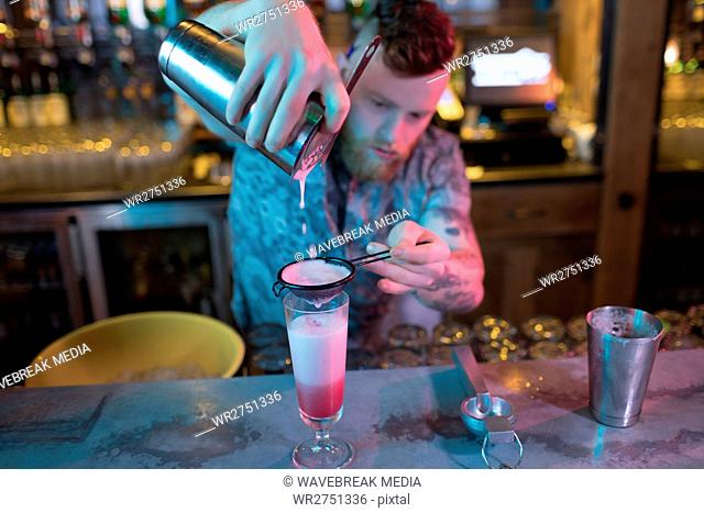 Bartender preparing a cocktail at counter