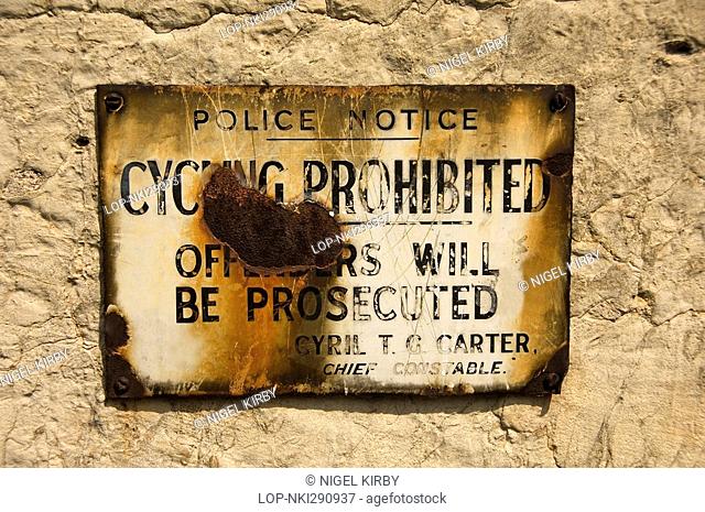 England, North Yorkshire, York, Old rusted enamel police plaque mounted on a stone wall advising cycling prohibited