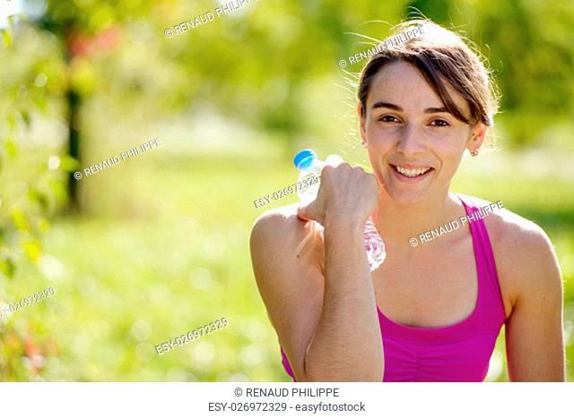 beautiful athletic girl drinking water after exercising